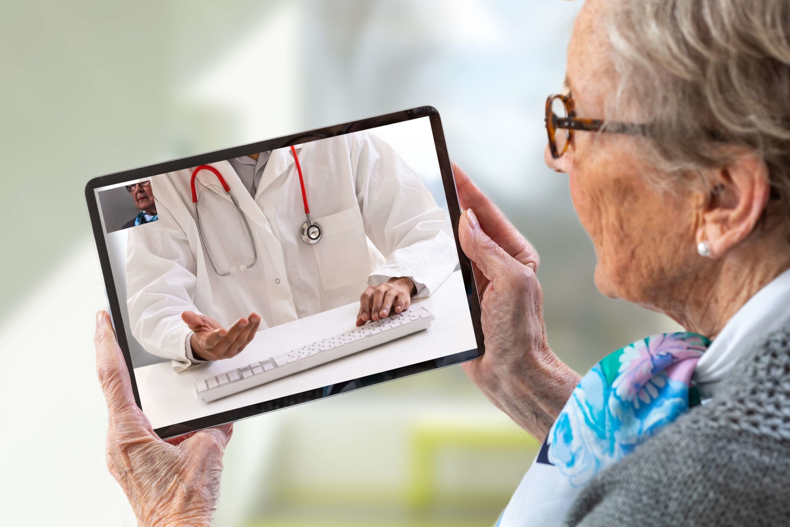 elderly woman examining tablet (min)